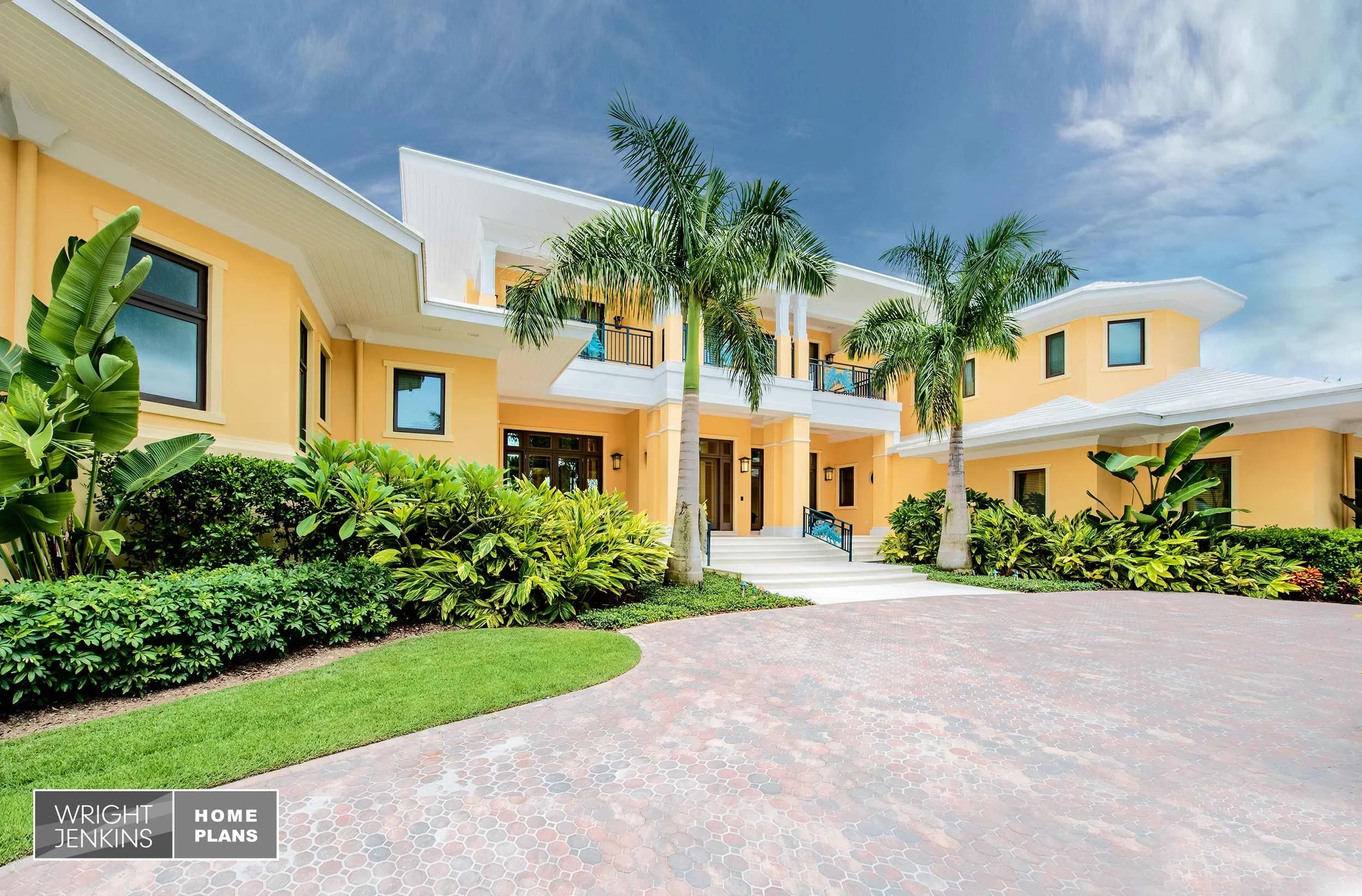 Stunning yellow house with palm trees and a clear blue sky